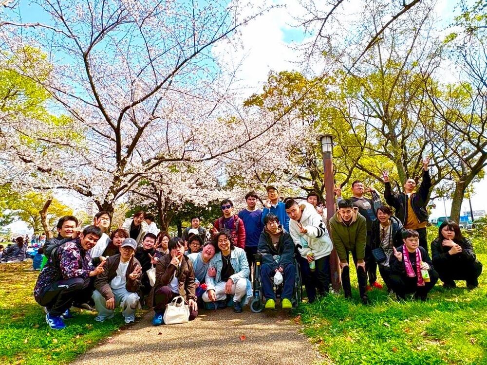 桜の下でのチーム集合写真